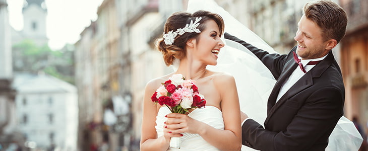 Bride and groom walk through San Diego streets holding hands