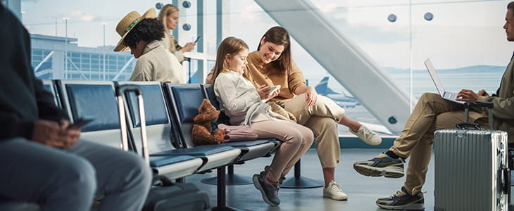 Travelers sit in an airport terminal