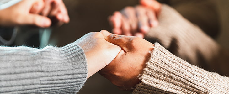 Worshippers hold hands in prayer