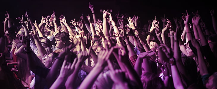 Concert attendees raise their hands as a crowd