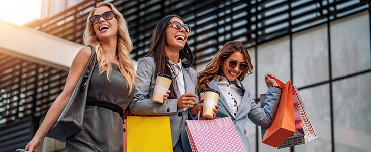 Three women shop in an outdoor mall